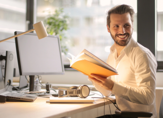 man reading a book at his desk