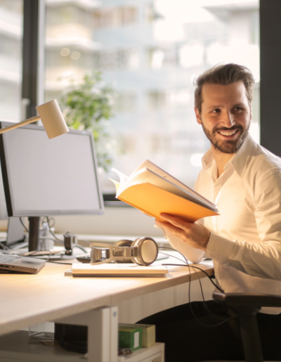 man reading a book at his desk